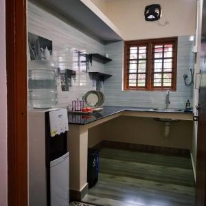 a kitchen with a counter and a sink in it at Nellakki Homestay in Madikeri