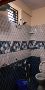 La salle de bains est pourvue d'une douche et de toilettes. dans l'établissement Nellakki Homestay, à Madikeri