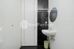 a white bathroom with a sink and a mirror at Palm Eight Mitra RedDoorz in Jakarta +15 photos