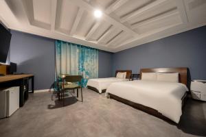 Habitación de hotel con 2 camas y TV en Hotel New Evergreen, en Mokpo