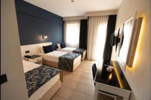 a hotel room with two beds and a television at MIR'AMOR GARDEN Resort Hotel-ALL INCLUSIVE in Antalya +37 photos