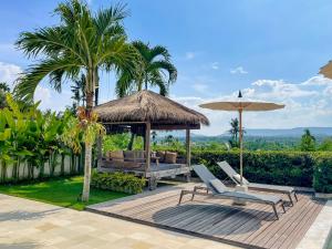 a patio with a gazebo and a bench and umbrella at Balidroomvilla's in Karangasem