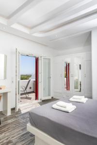 a white bedroom with two beds and a desk at Depis Edem luxury villas naxos in Plaka