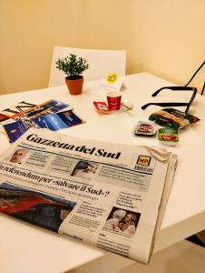 a newspaper sitting on top of a white table at Suleima B&B Messina Centro in Messina