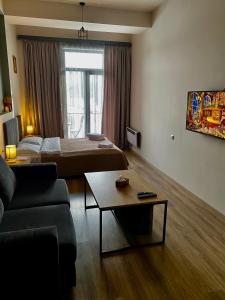 een kamer met 2 bedden, een bank en een tafel bij Apartment #102 in aparthotel in Tsachkadzor