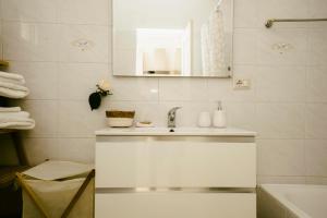 bagno bianco con lavandino e specchio di Le 3 Volte a Cursi