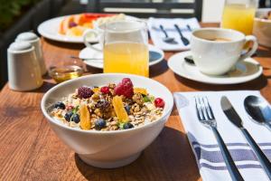 a bowl of cereal and fruit on a wooden table at Marvie Hotel & Health in Split