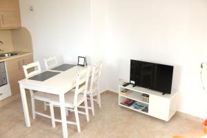 kuchnia z białym stołem z krzesłami i telewizorem w obiekcie Relax en primera linea A w mieście El Campello