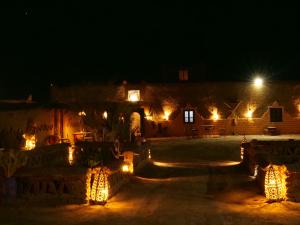 Una vista nocturna de un edificio con luces. en hostels Planet Sahara, en Merzouga