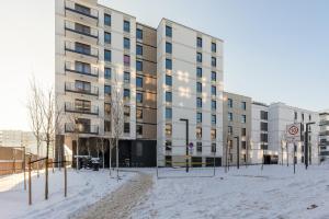 un edificio con nieve delante en Cozy Studio Apartment in Ursus District by Renters, en Varsovia