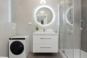baño blanco con lavadora y espejo en Cozy Studio Apartment in Ursus District by Renters, en Varsovia