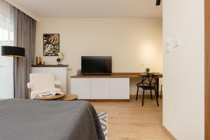 1 dormitorio con 1 cama y escritorio con TV en Cozy Studio Apartment in Ursus District by Renters, en Varsovia