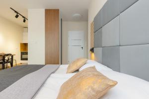 1 dormitorio con 1 cama blanca grande y 2 almohadas en Cozy Studio Apartment in Ursus District by Renters, en Varsovia