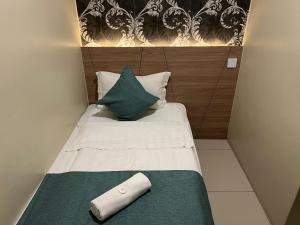 クアンタンにあるKUANTAN BESERAH BUDGET HOTELの小さなベッド(緑と白の毛布、枕付)