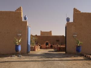 un patio de un edificio con dos jarrones azules en kasbah Planet Sahara, en Merzouga