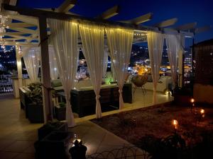 un patio all'ultimo piano con vista sulla città di notte di TaliaKà B & B a Città di Lipari