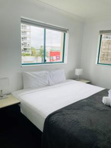 duże białe łóżko w pokoju z oknem w obiekcie Aruba Beach Resort w mieście Gold Coast