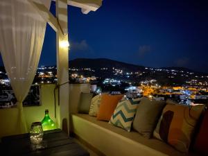 un divano posto sopra un balcone di notte di TaliaKà B & B a Città di Lipari