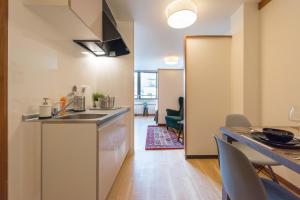 a kitchen with a sink and a table with chairs at TORA HOTEL Tokyo Ueno 寅ホテル 上野 D in Tokyo