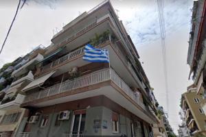um edifício com uma bandeira francesa numa varanda em Travelers in Athens em Atenas