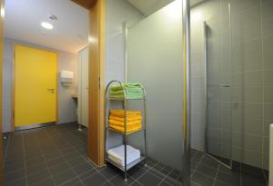 uma casa de banho com um chuveiro e um suporte com toalhas em Bildungs- uns Tagungshäuser Vierzehnheiligen Diözesanhaus em Bad Staffelstein