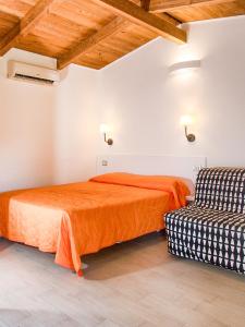 una camera con due letti e una sedia di Arco delle Rose Rooms ad Agropoli