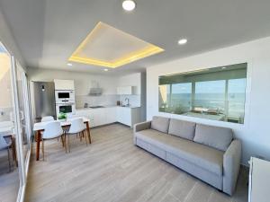 een woonkamer met een bank en een tafel bij ATICO VISTAS MAR PLAYA LAS CANTERAS in Las Palmas de Gran Canaria