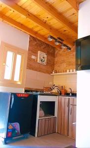 a kitchen with a refrigerator in the middle of it at Cozy Studio in Asala of Dahab1 in Dahab