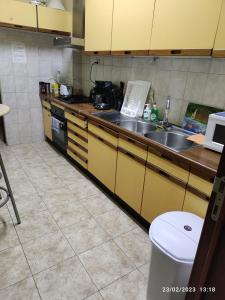 a kitchen with yellow cabinets and a sink at Room in Guest room - Chambre A Brucelles D in Brussels