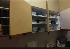 a kitchen cabinet with plates and dishes in it at Room in Guest room - Chambre A Brucelles D in Brussels