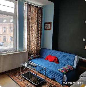 - un canapé bleu dans le salon doté d'une fenêtre dans l'établissement Room in Guest room - Chambre A Brucelles D, à Bruxelles