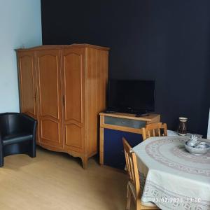 sypialnia z drewnianą szafką i stołem z telewizorem w obiekcie Room in Guest room - Chambre A Brucelles D w Brukseli