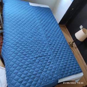 ein Bett mit blauer Bettwäsche darüber in der Unterkunft Room in Guest room - Chambre A Brucelles D in Brüssel