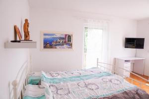 ein weißes Schlafzimmer mit einem Bett und einem TV in der Unterkunft Ferienhaus Falkenstein in Frauenau