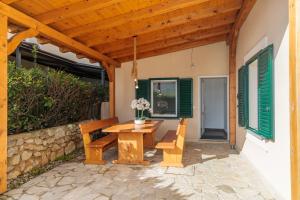 a wooden patio with a wooden table and benches at Apartments TM in Krk