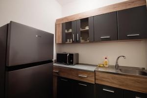 a kitchen with a stainless steel refrigerator and a sink at Complex Omnia - Apartamente Husi in Huşi
