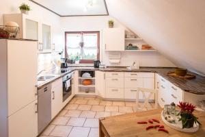 eine Küche mit weißen Schränken und einem Holztisch in der Unterkunft Ferienwohnung Ziske in Bad Wildungen