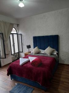 1 dormitorio con 1 cama grande con sábanas y almohadas rojas en Hotel Suspiro, en San Miguel de Allende