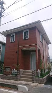 una casa roja con escaleras delante en 萩シーサイド堀内, en Hagi