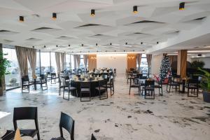 a dining room with tables and chairs and a christmas tree at HOTEL NEST in Bijeljina