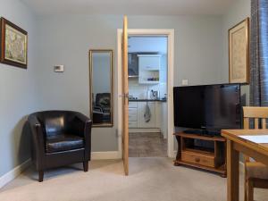 a living room with a television and a chair at Gables Farm, Self contained flat by Middlewood Way in Poynton