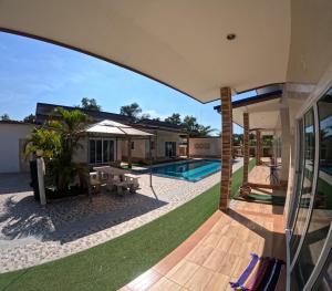 a house with a swimming pool and a patio at Pattaya pool villa in Ban Huai Yai