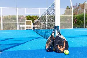 zwei Tennisschläger und ein Tennisball auf einem Platz in der Unterkunft Valtur Il Cormorano Resort & Spa in Grisolia