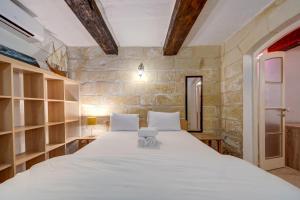 een slaapkamer met een groot wit bed in een kamer bij Vallettastay City break apartments in Valletta
