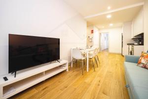 ein Wohnzimmer mit einem großen Flachbild-TV in der Unterkunft Casa Del Sol Apartamento in Gijón