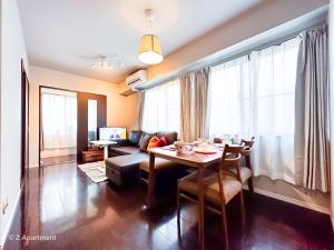 un soggiorno con un tavolo e un divano di Z Apart ment 大阪通天閣玩具街旅居 ad Osaka
