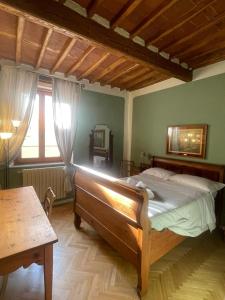 een slaapkamer met een bed, een tafel en een raam bij EstateGuard Group - Prestige Rooms Lucca City Center in Lucca