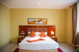 una camera con un grande letto bianco di Tiffany Diamond Hotels LTD - Makunganya a Dar es Salaam