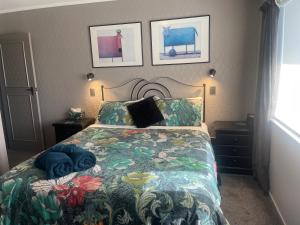 a bedroom with a bed with a colorful blanket at The Belfry in Taupo