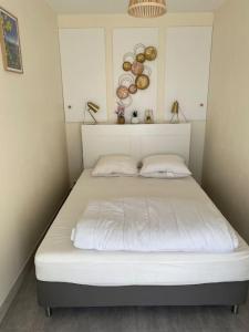 1 cama blanca con 2 almohadas en una habitación en Joli appartement calme avec vue piscine, en Mandelieu-la-Napoule 11 fotos más